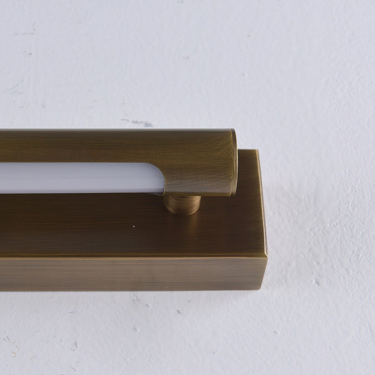 The Penrith Linear Wall Sconce illuminating a piece of artwork on the wall.