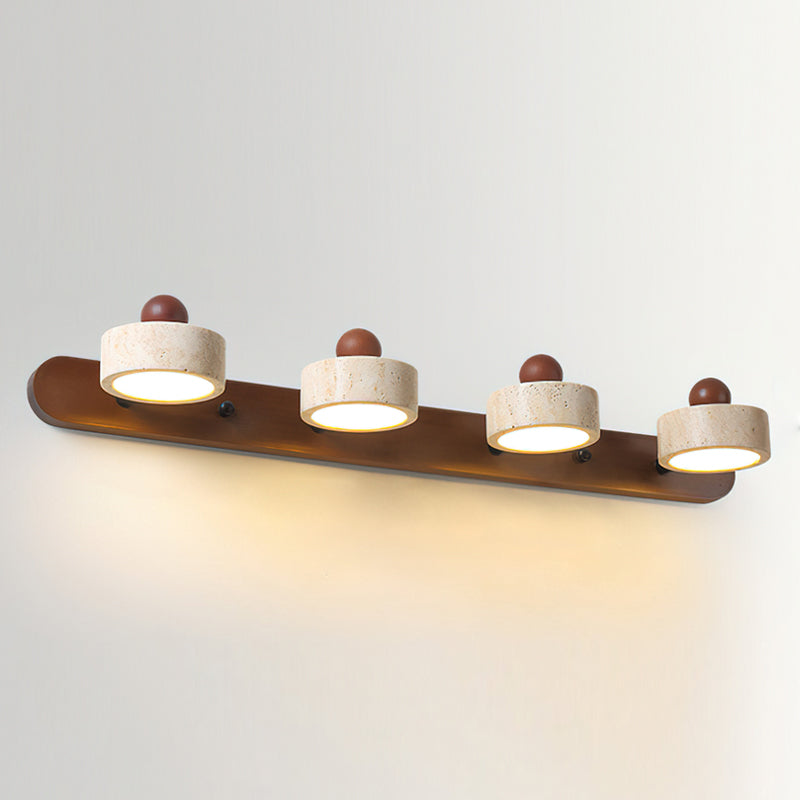 The Piero Travertine Wall Lamp shown against a dark wall to highlight its form and material.