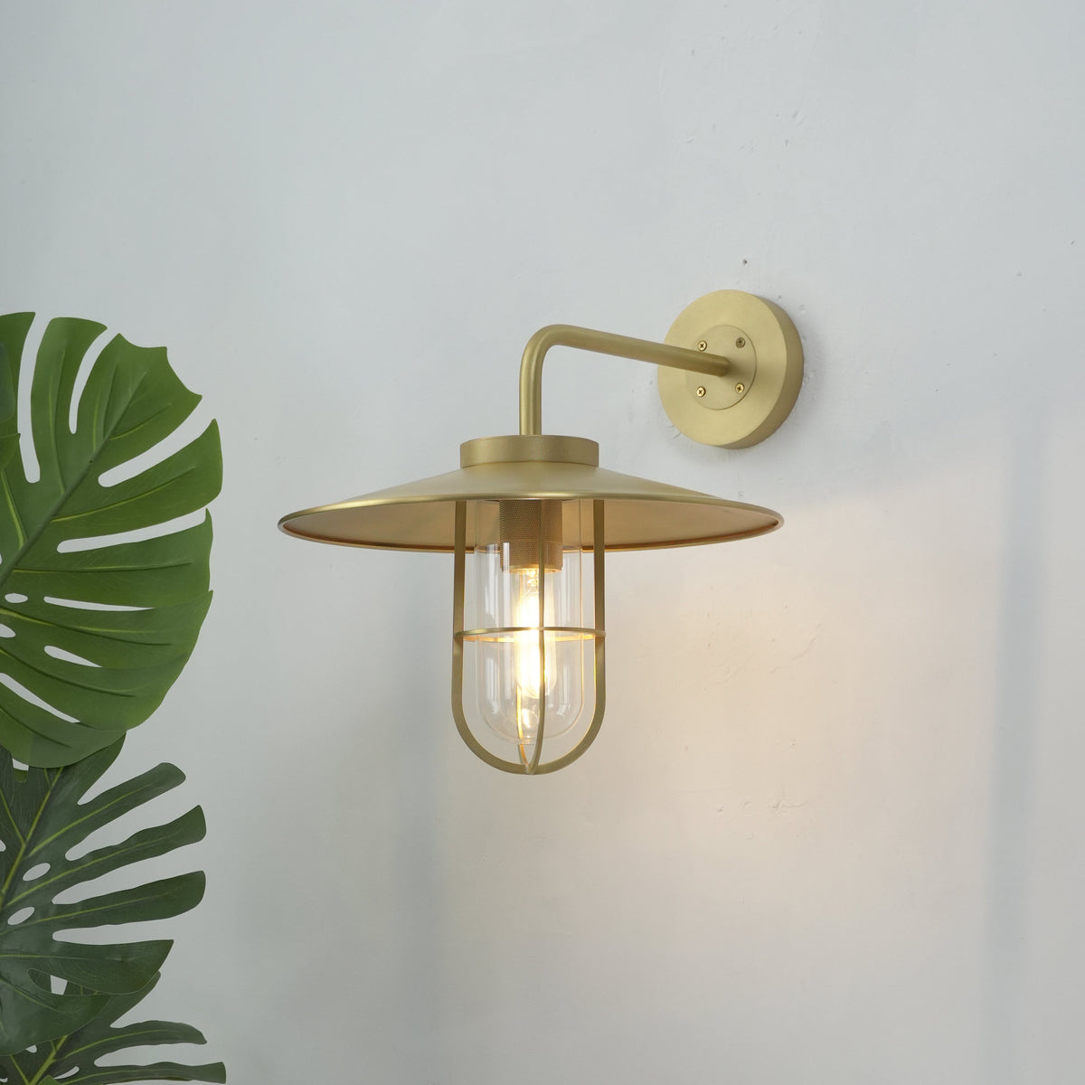 Angled view of the Portree Wall Light in brass, highlighting its industrial design.