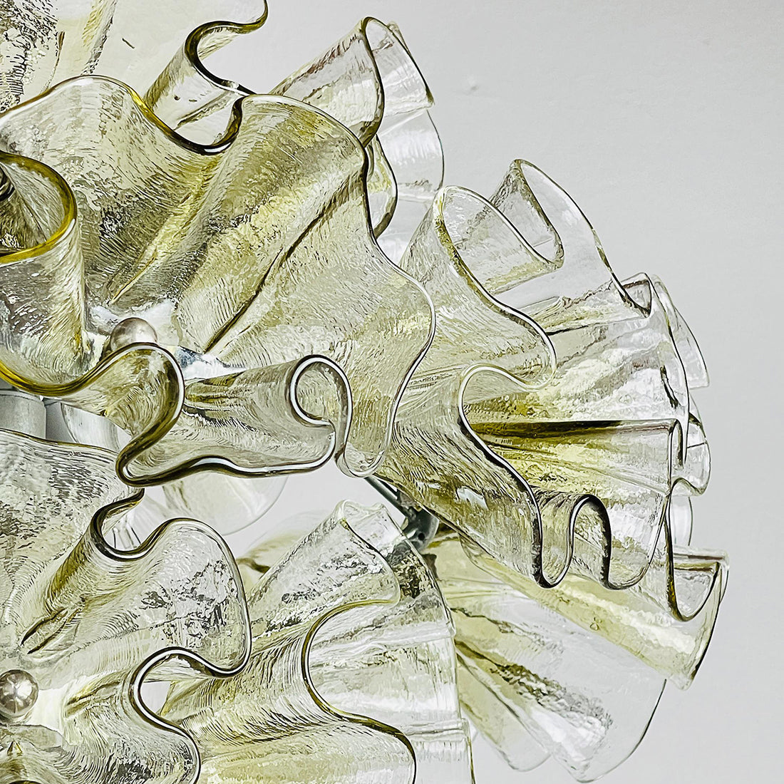 A mix of green and clear glass petals on the chandelier.