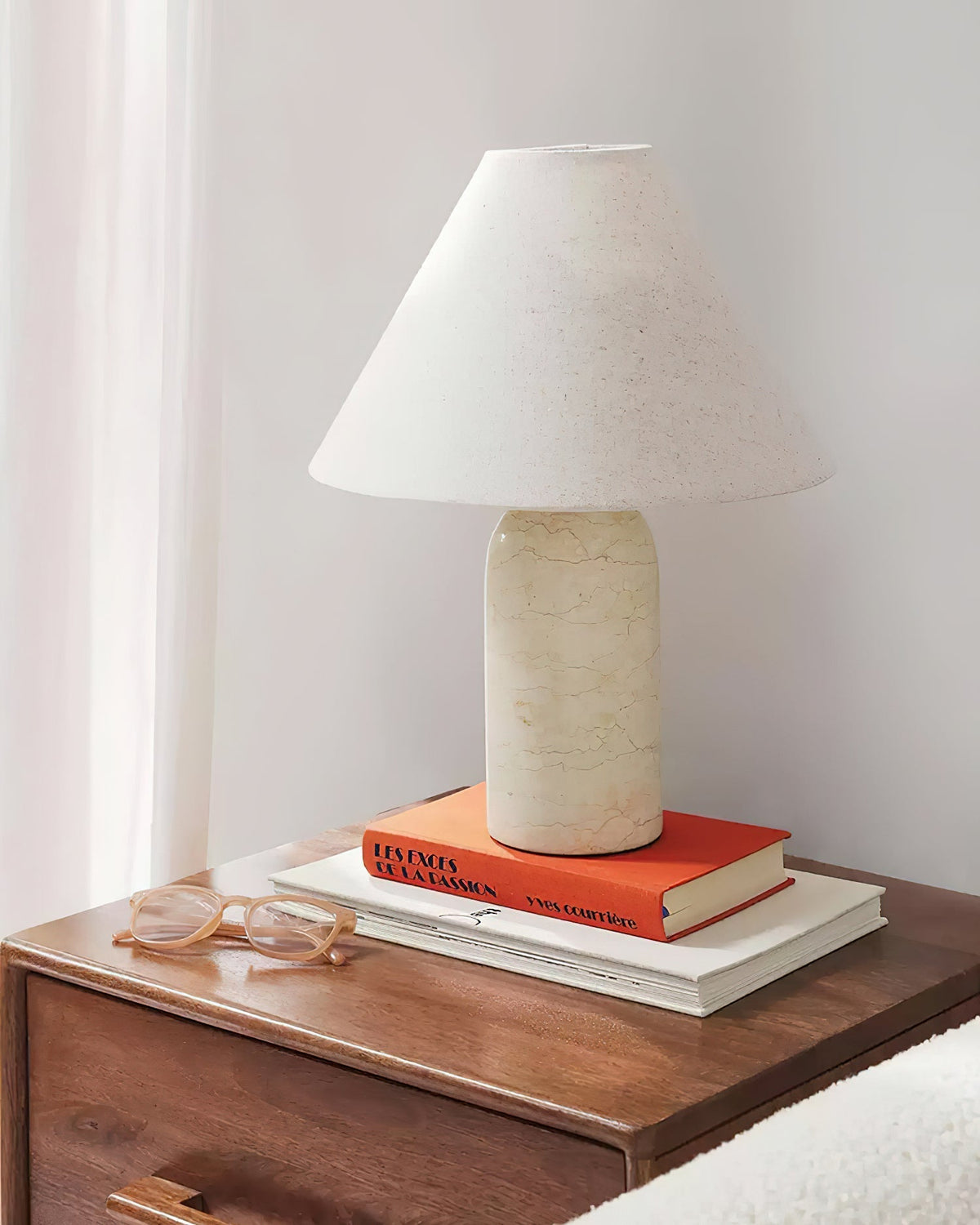 The lamp shown on a bedroom nightstand, providing warm ambient light.