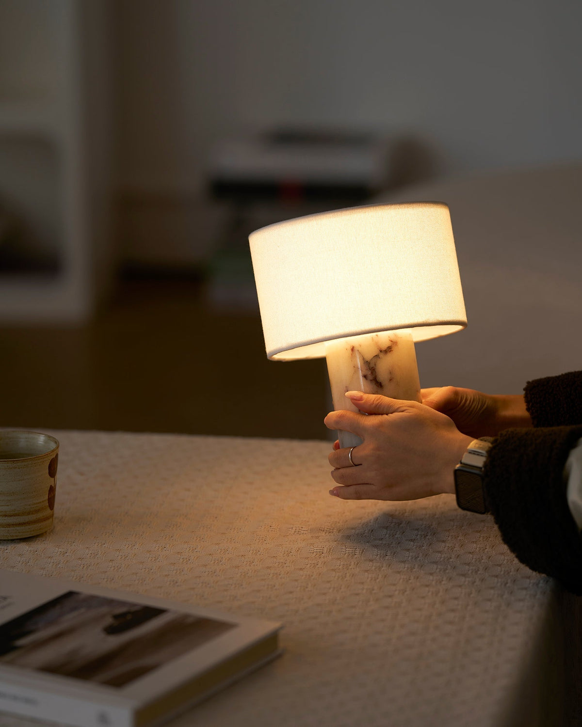 The lamp casting a warm glow on a nearby wall.