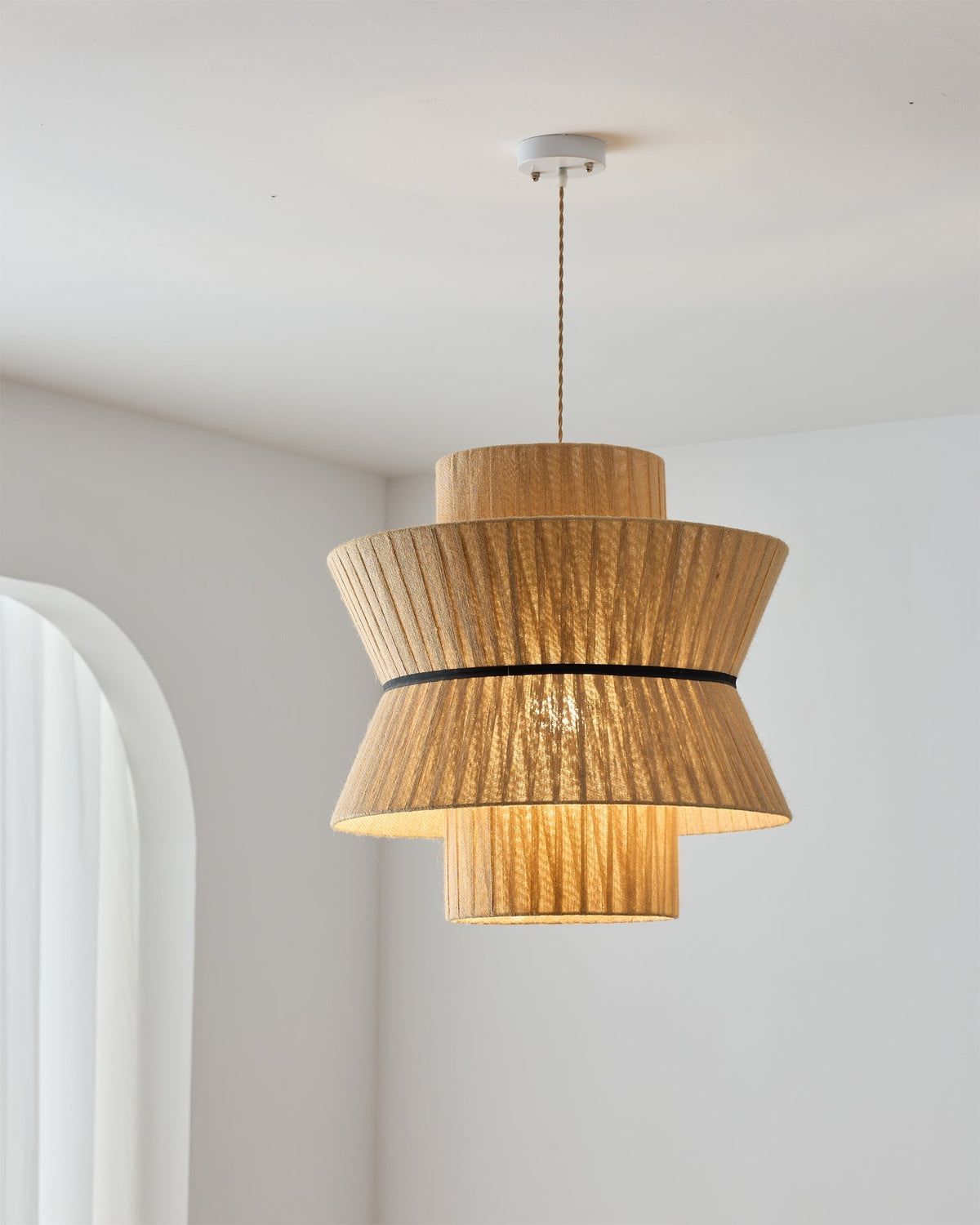 The smallest size of the Sicel Pendant Light in a cozy reading nook.