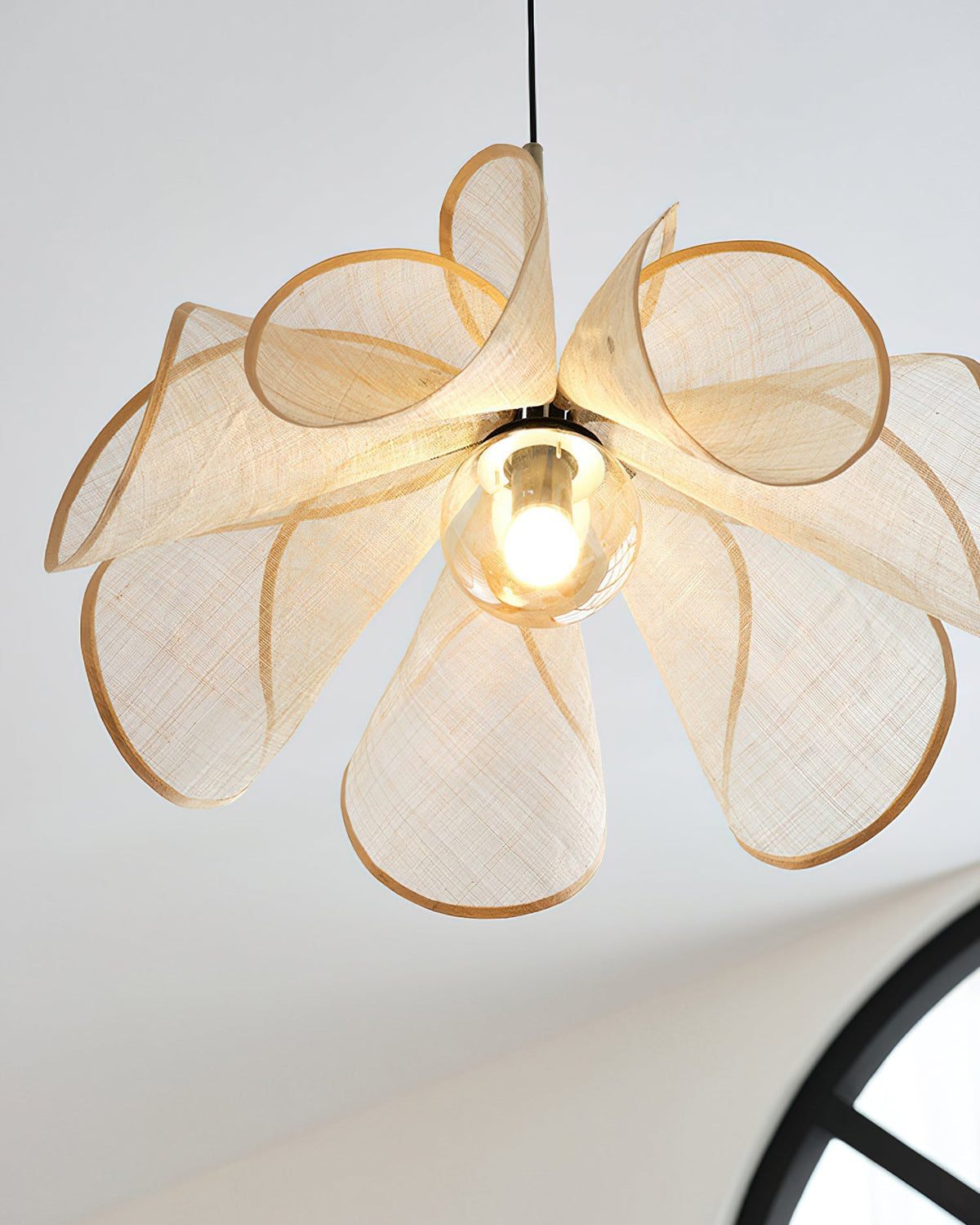 Angled view of the light brown pendant lamp, highlighting its floral silhouette.