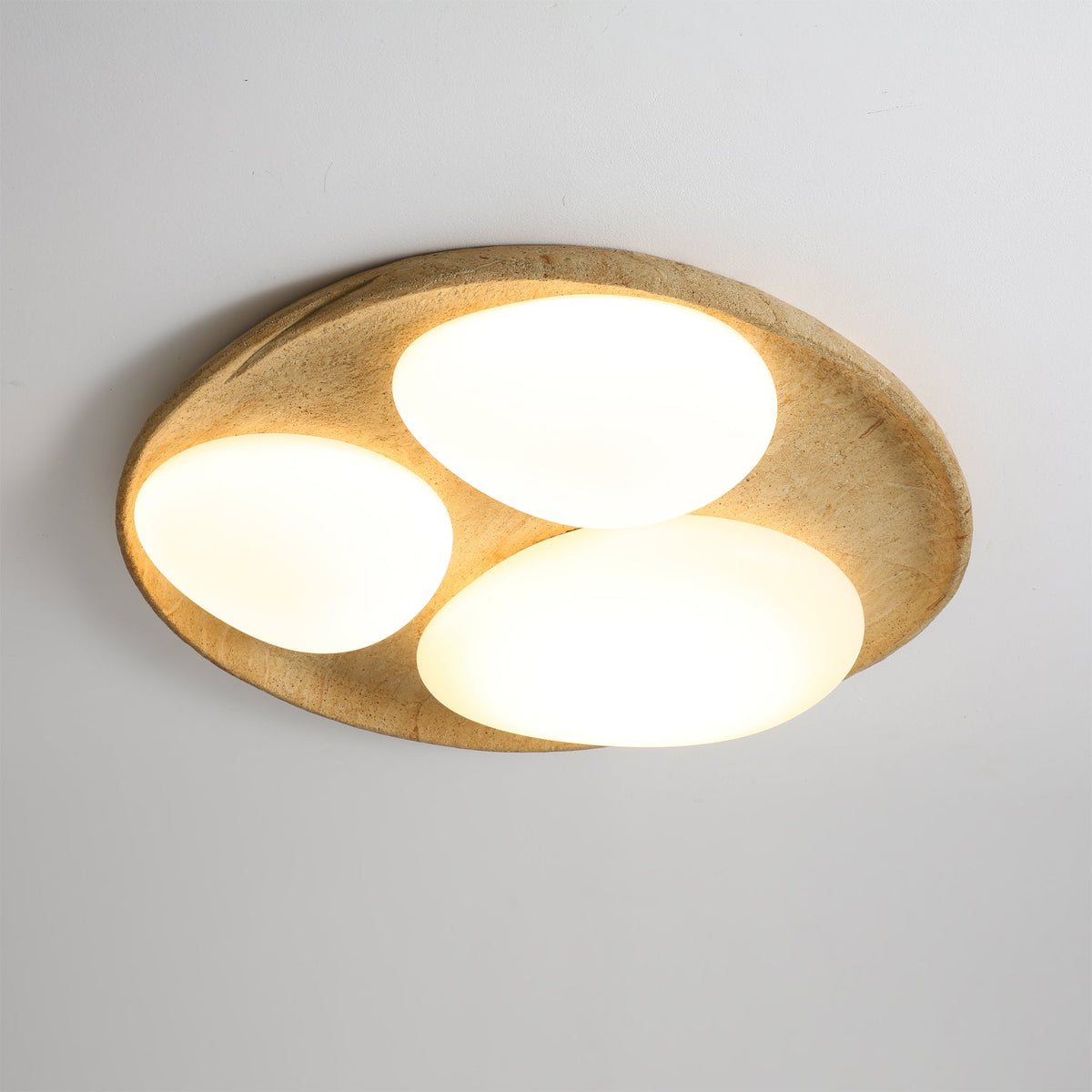 The organic shape of the Topo Ceiling Light, resembling river stones.
