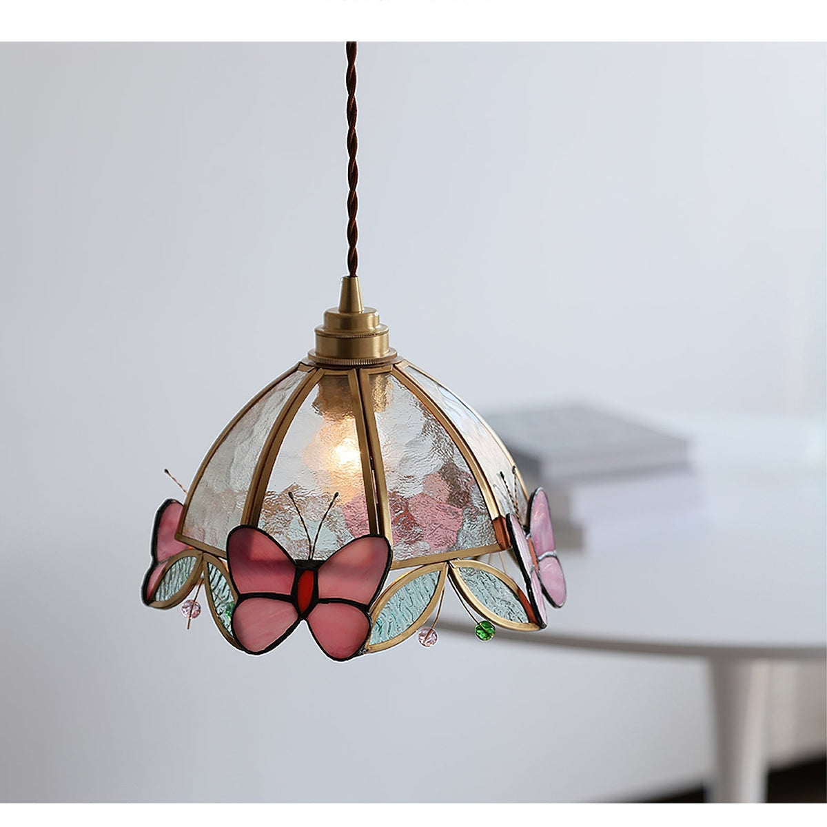 Side view of the Valinte pendant light with its gold metal frame.