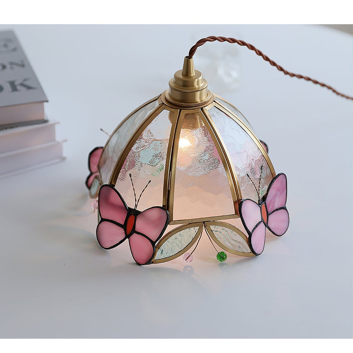 Close-up of the Valinte pendant light showing the pink and clear glass butterfly design.