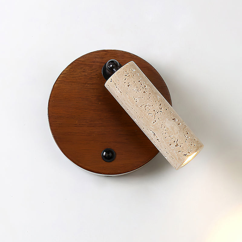 The wall lamp providing focused task lighting over a bedside table.