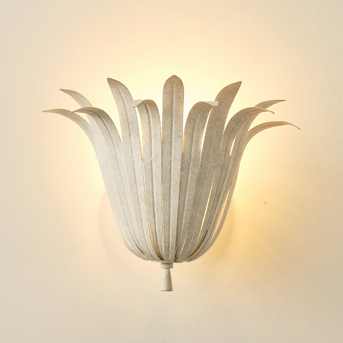Unlit Vicenzio Leaf Wall Lamp in gold against a dark wall.