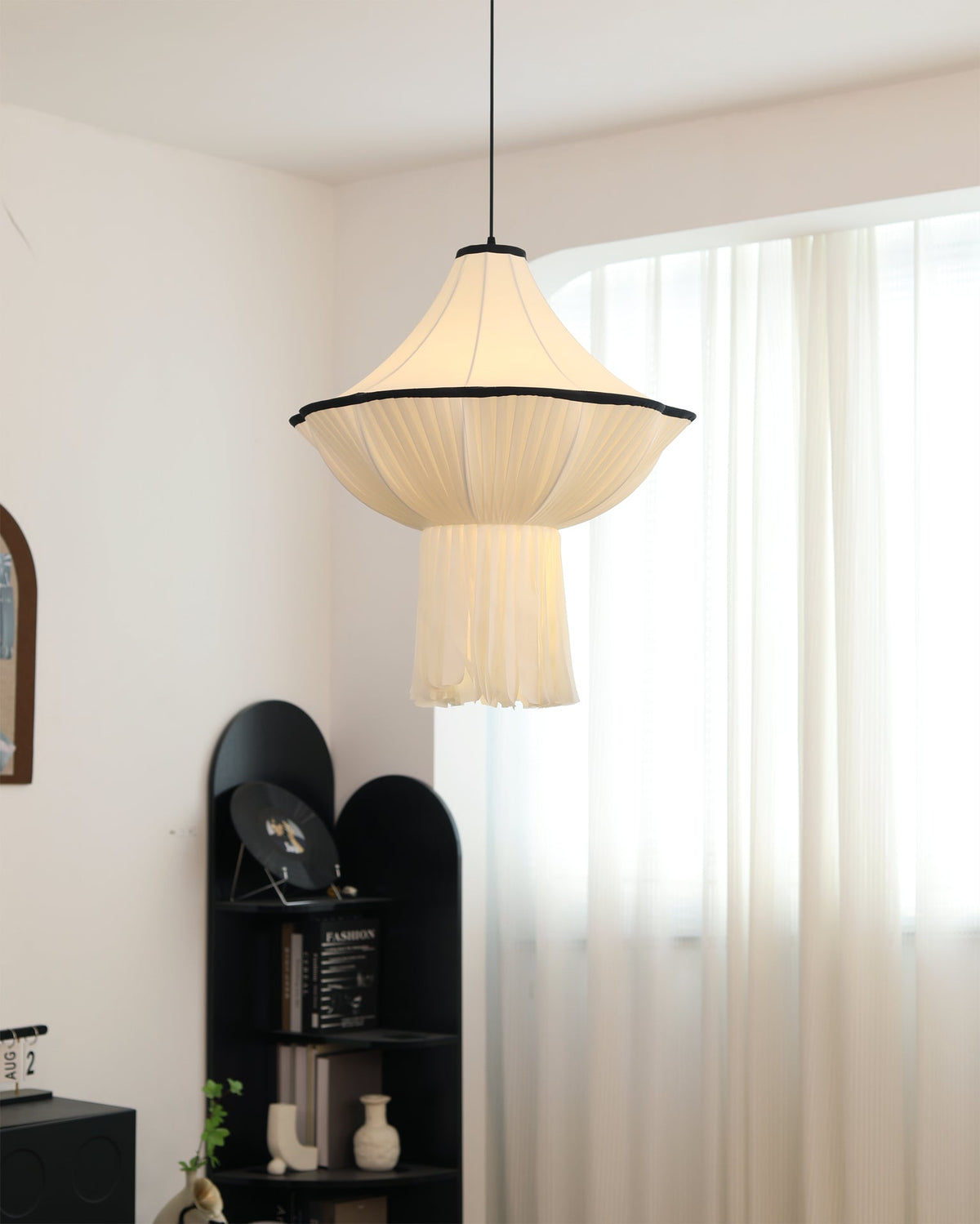 The black version of the Wildon Pendant Light hanging in a minimalist space.