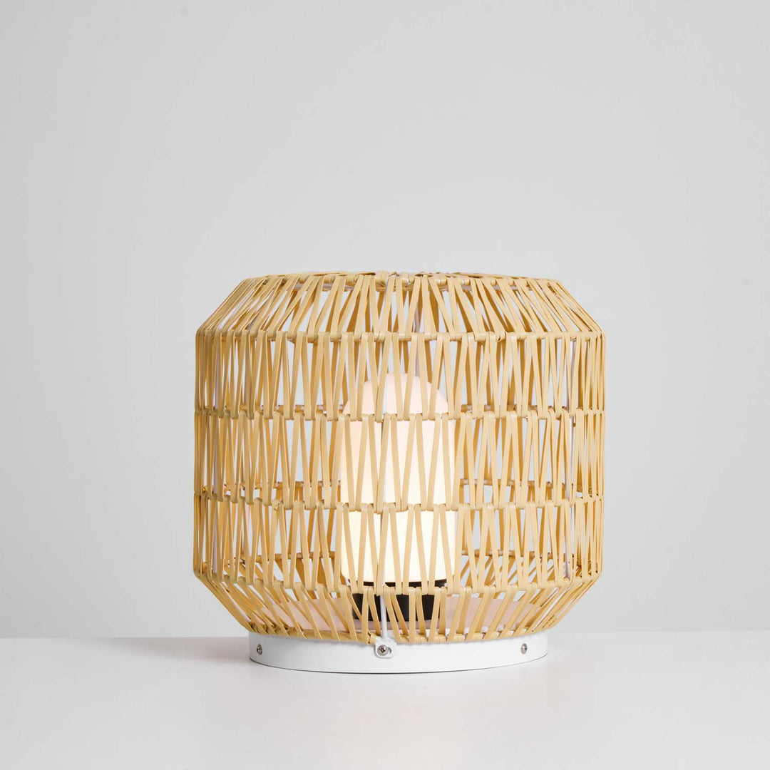 The outdoor lamp shown illuminating a patio setting at dusk.