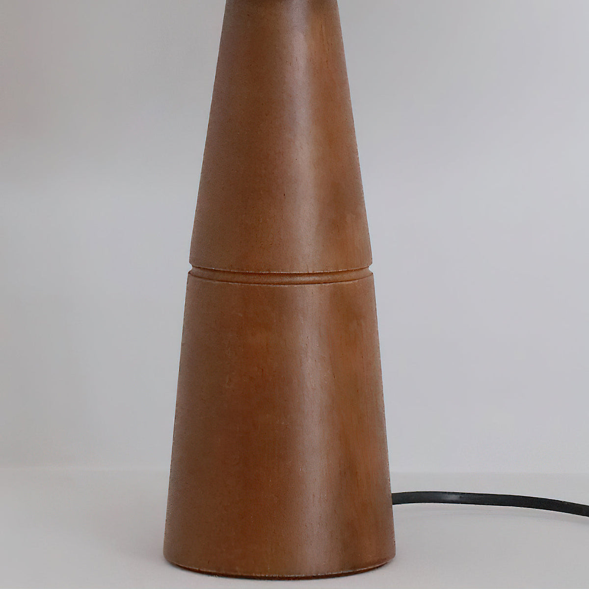 The wood grain detail of the lamp's walnut-colored base.