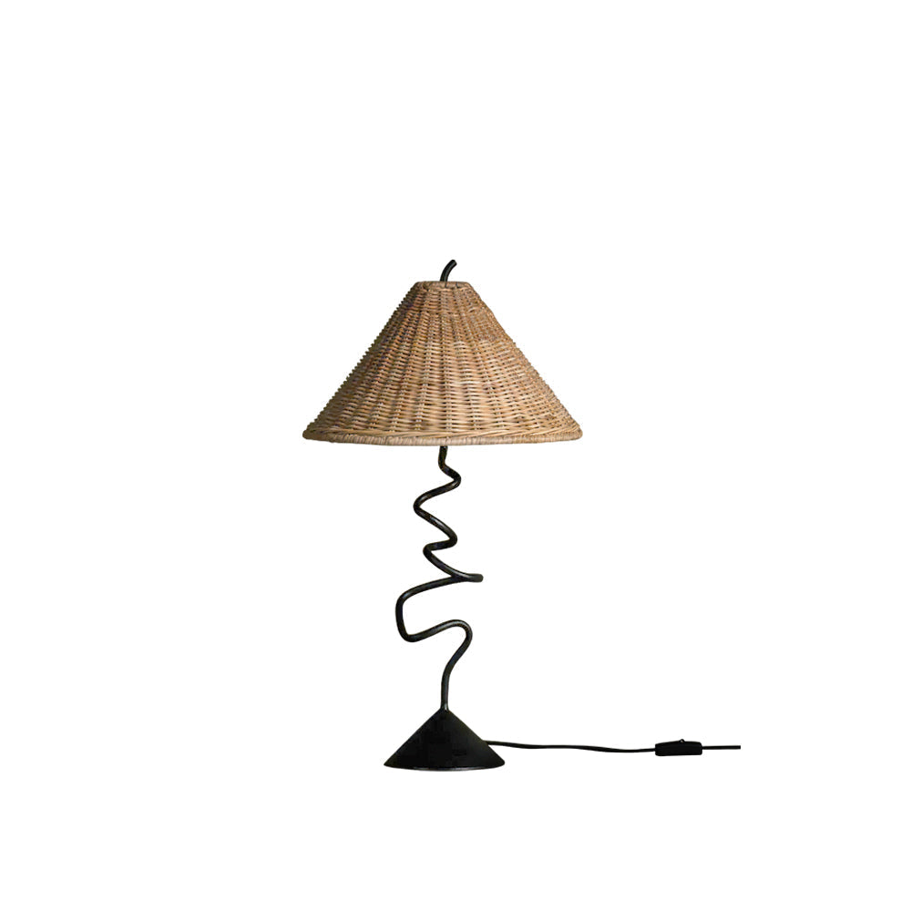 Zigzag Table Lamp with a black metal base and a natural rattan shade, shown on a wooden surface.