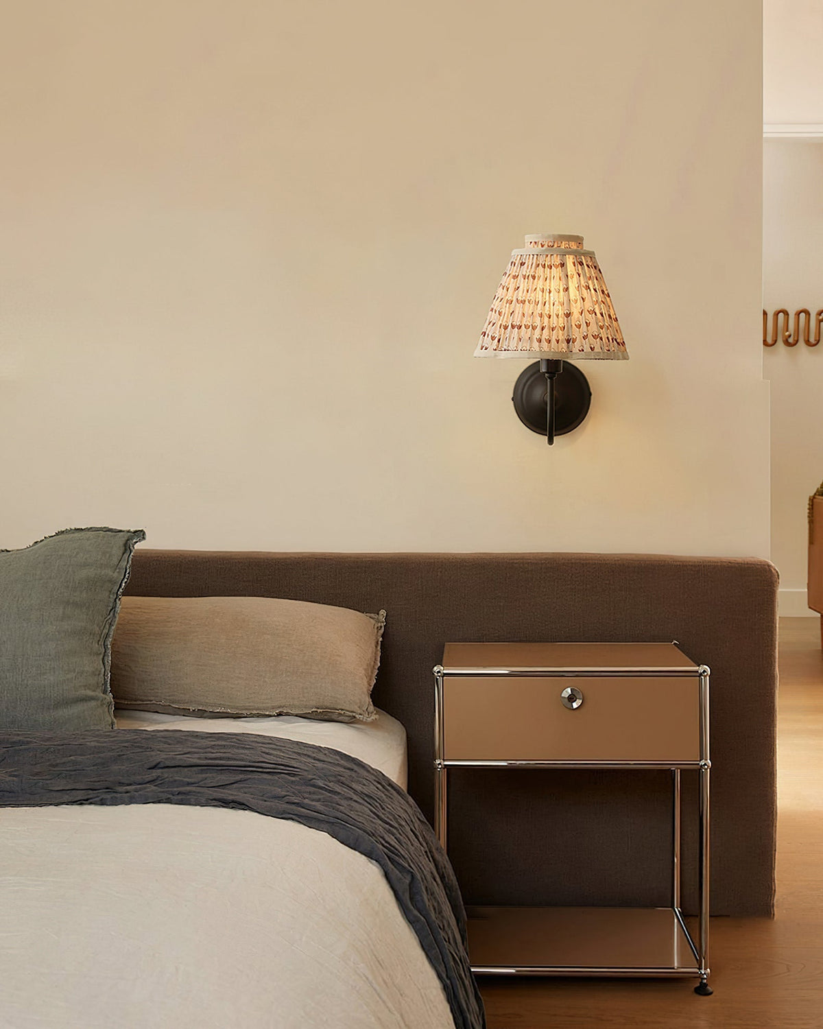 Elbow Wall Light installed above a bedside table in a bedroom.
