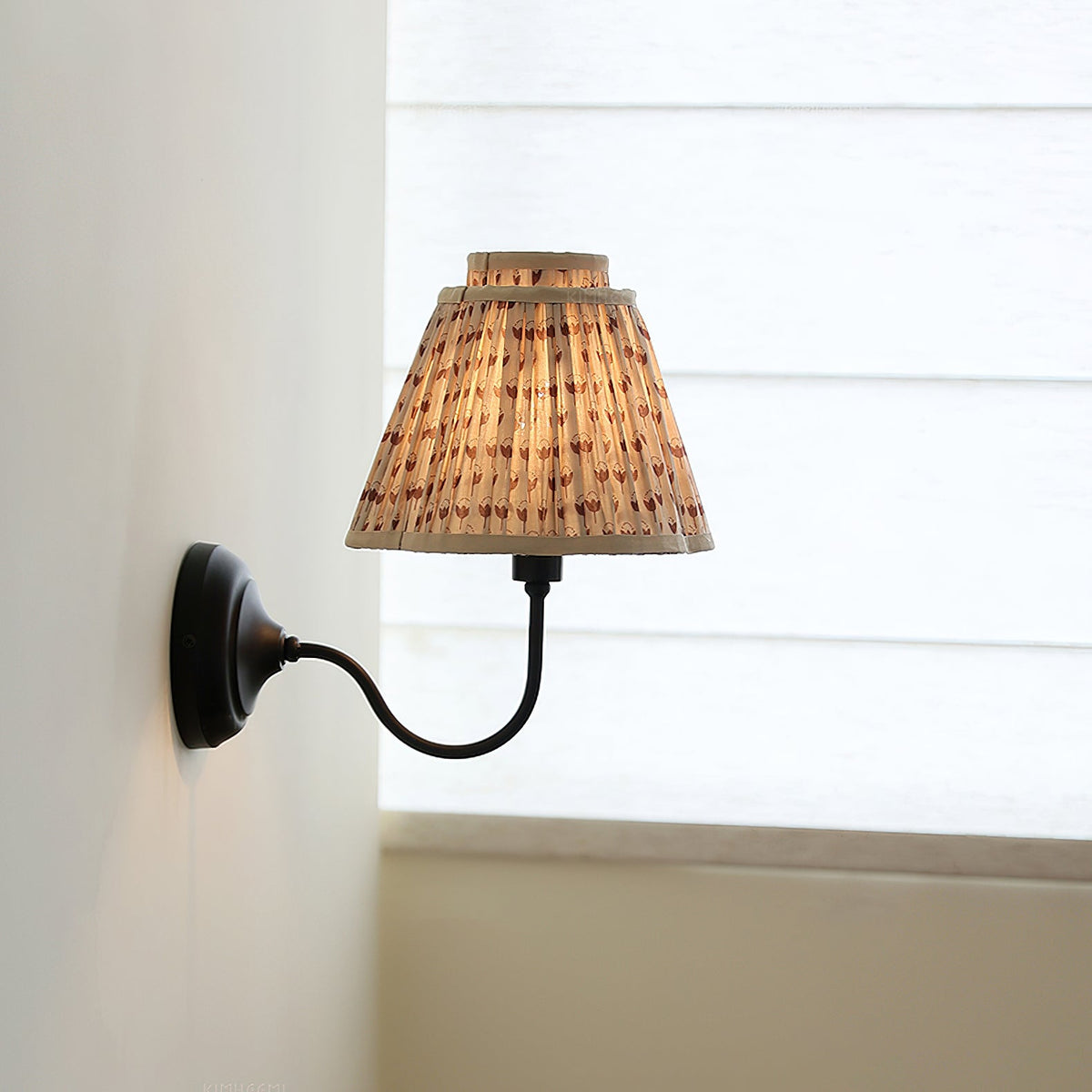 Side view of the Elbow Wall Light with a green floral shade.