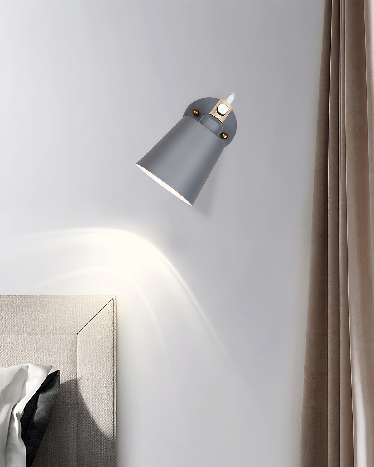 Copita Wall Lamp in grey finish mounted above a nightstand.